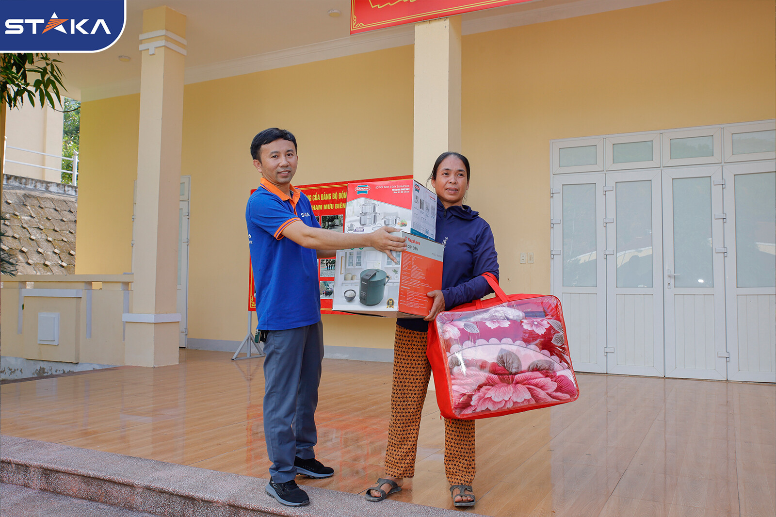 Hình ảnh người dân vui vẻ nhận quà từ STAKA