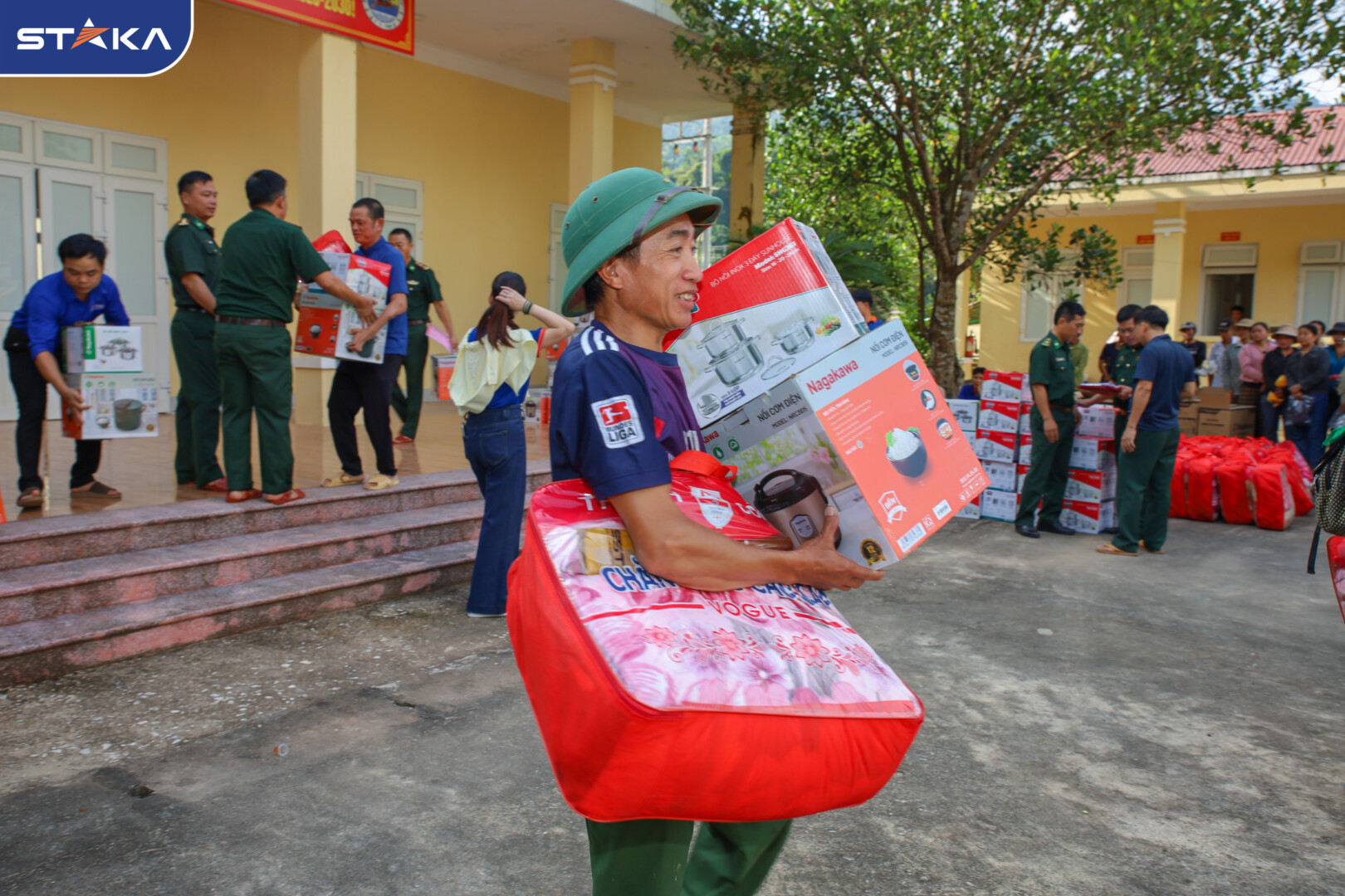 Hình ảnh người dân vui vẻ nhận quà từ STAKA